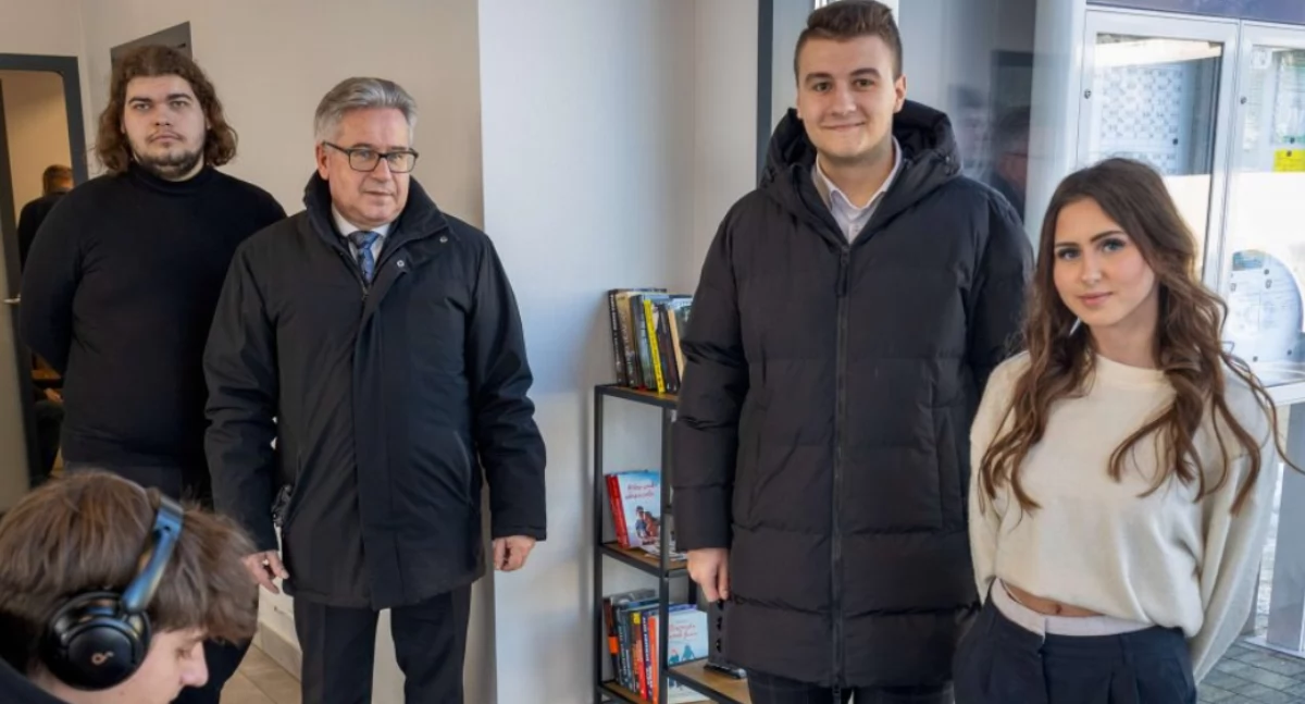 Klaudiusz Fryz, burmistrz Kazimierz Moskal, nowy przewodniczący MRM Michał Czuba a pomiędzy nimi regał z książkami w poczekali dworca autobusowego w Ropczycach. 