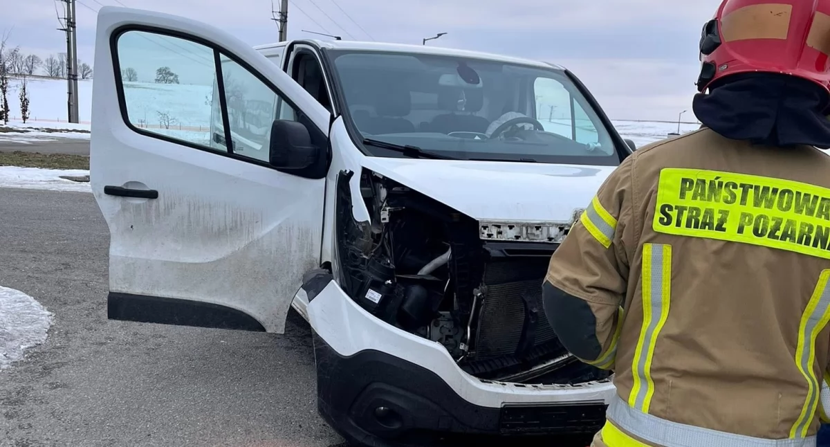 Furgonetka renault z rozbitym w czasie kolizji przodem. Z samochodu wylały się płyny eksploatacyjne. 