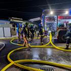  Wozy bojowe z rozłożonymi wężami i strażakami podczas pożaru garażu w Czarnej...